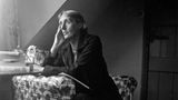 Virginia Woolf sitzt an einem Tisch