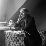 Virginia Woolf sitzt an einem Tisch