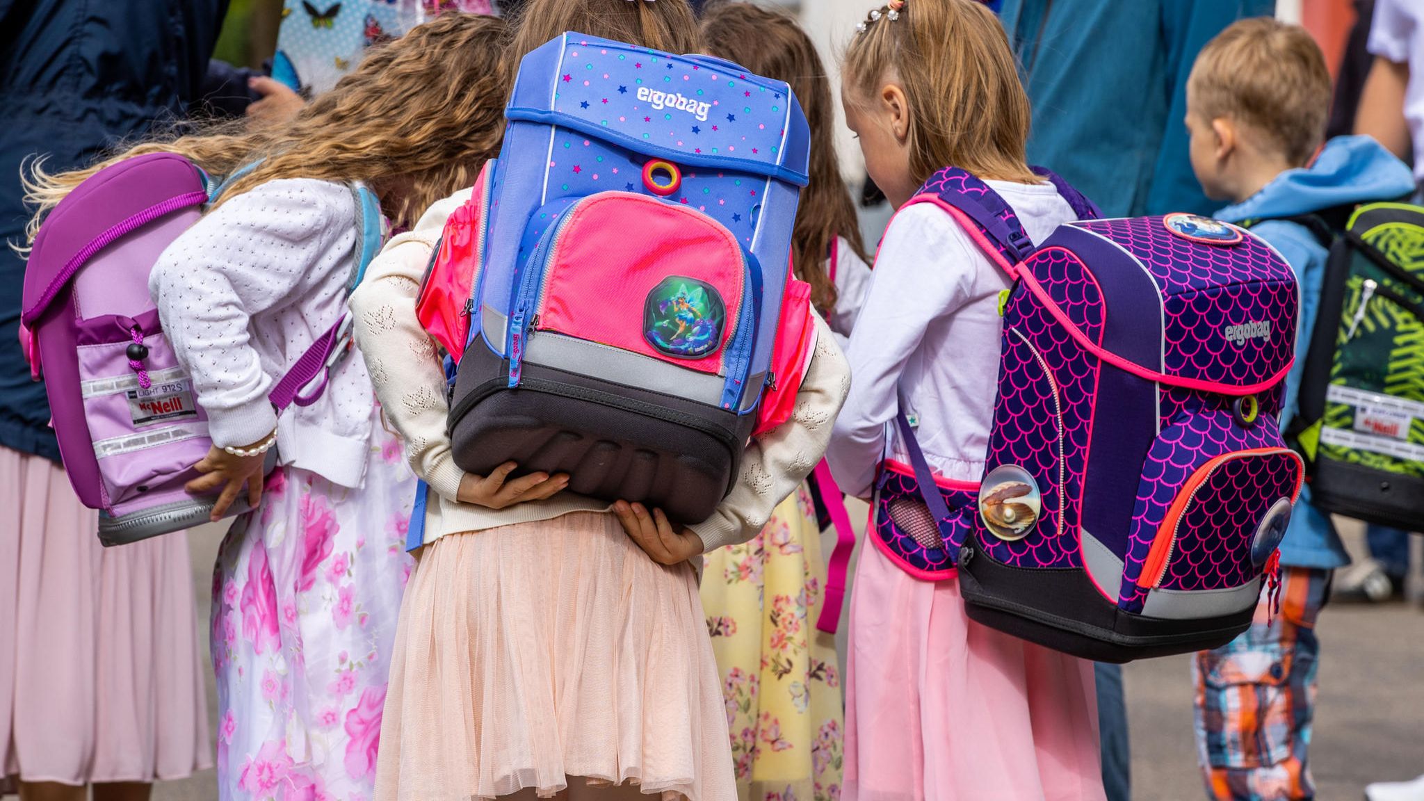 Mädchen von hinten mit Schulranzen auf dem Rücken Mädchen von hinten mit Schulranzen auf dem Rücken