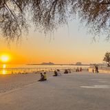 Strand mit Menschen bei Sonnenuntergang