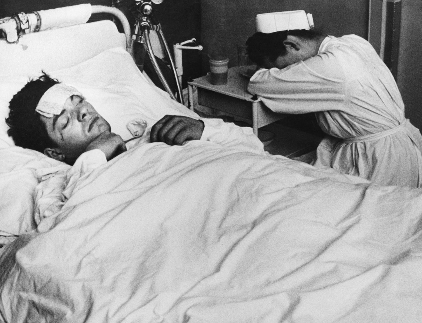 Krankenschwester schläft am Bett eines Patienten