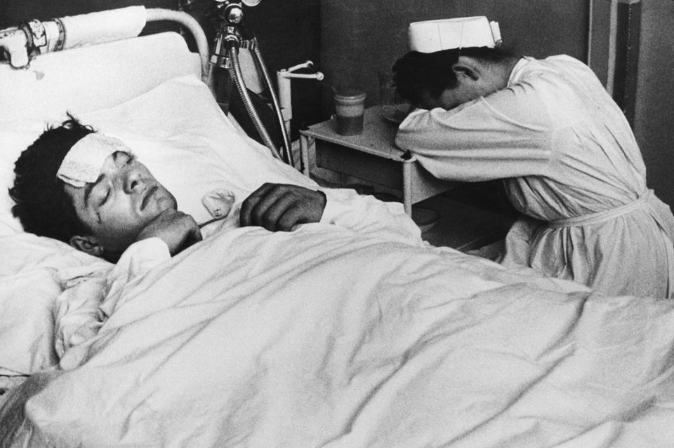 Krankenschwester schläft am Bett eines Patienten