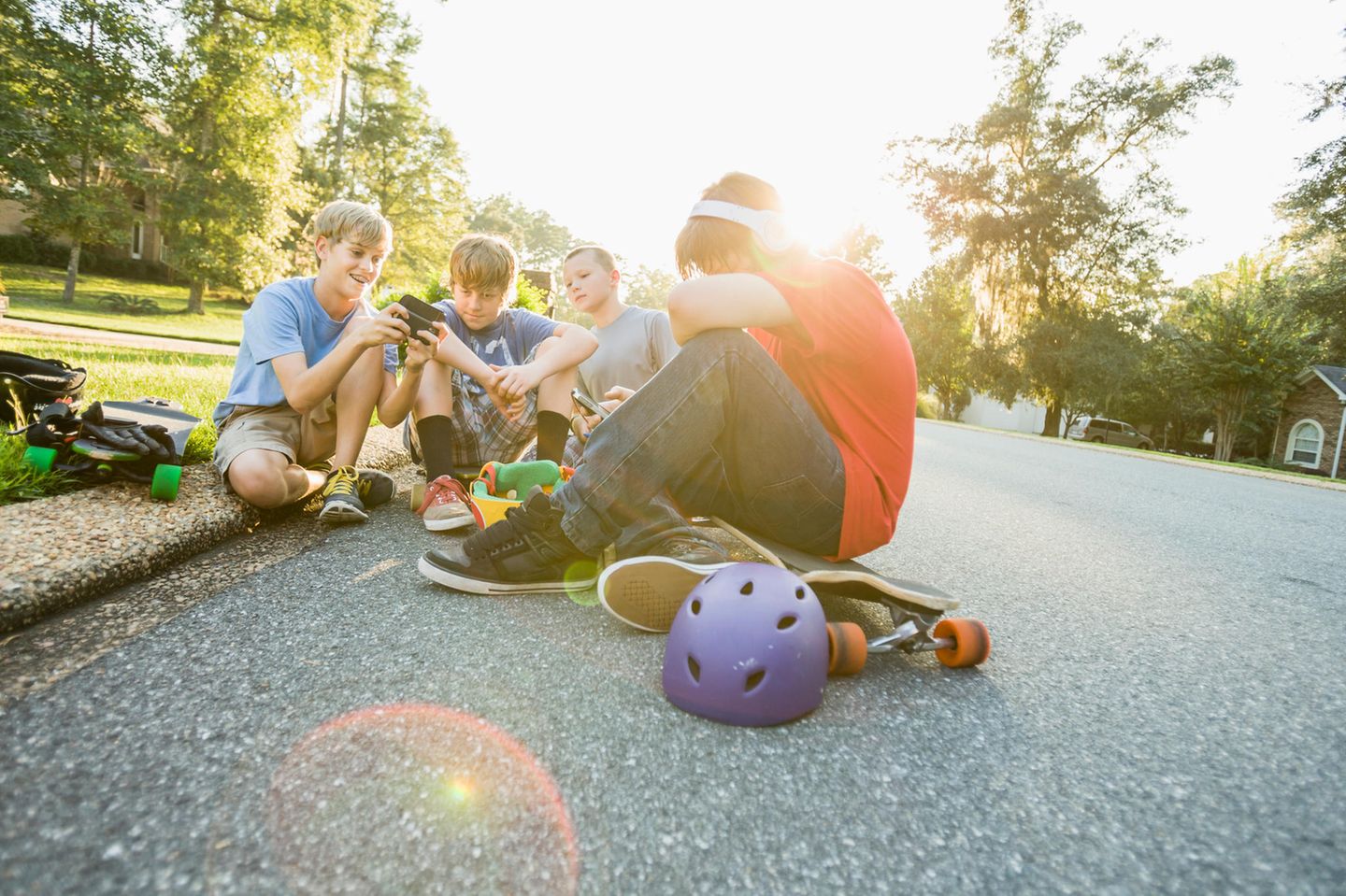 Eine Gruppe von Kindern sitzt beisammen und zeigt sich Inahlte auf dem Smartphone