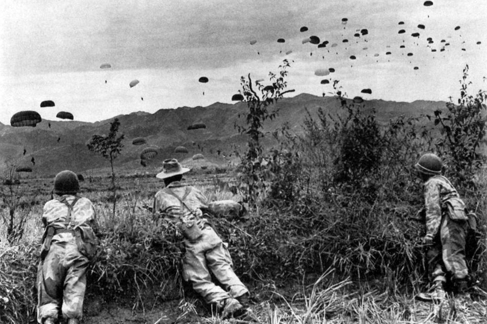 Zwei Soldaten beobachten landende Fallschirmspringer