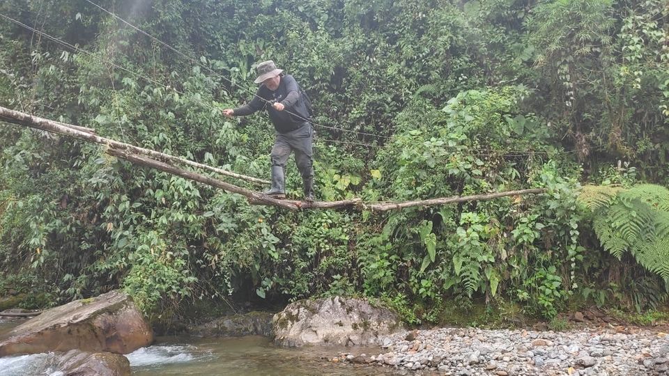 Pedro Varela hangelt sich auf einer einfachen Brücke über einen Bach