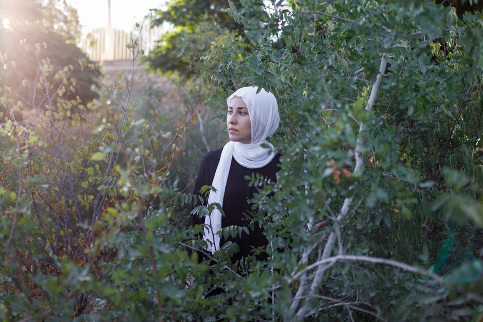 Deema Assaf steht zwischen Bäumen
