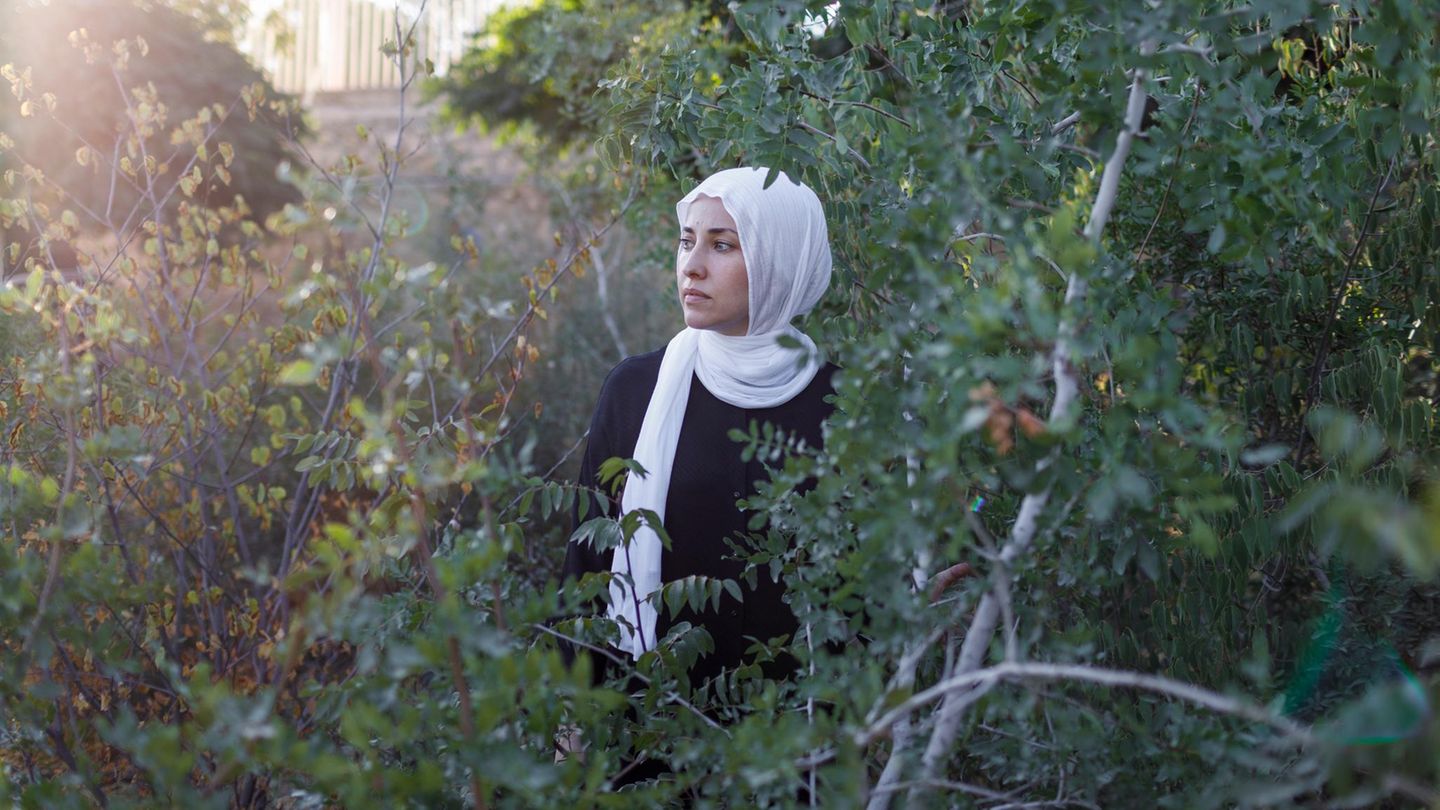 Deema Assaf steht zwischen Bäumen