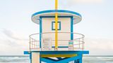 Turm in Gelb-Blau am Miami Beach, erbaut 2018 Seit Sommer 2023 stehen im Sand vor Miami sehr besondere Strandwärterhäuschen. Die ersten fünf ihrer Art hatte Architekt William Lane entworfen, kurz nachdem 1992 Hurrikan "Andrew" den Bundesstaat Florida verwüstet hatte.