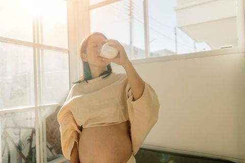 Eine schwangere Frau trinkt ein Glas Milch