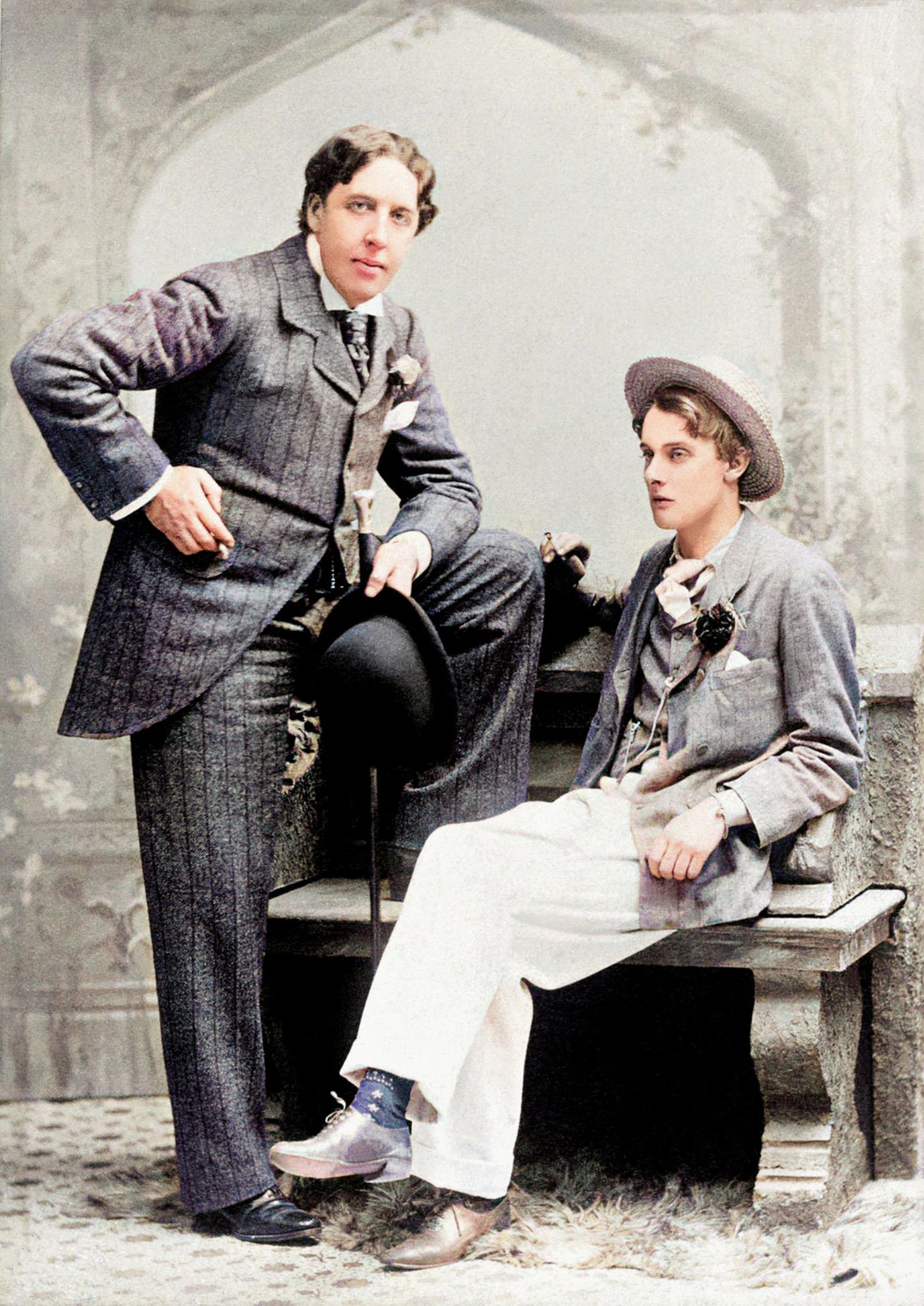 Oskar Wilde und Alfred Douglas: Liebe gegen jede Konvention Oskar Wilde im dunklen Anzug, stehend, neben ihm auf einer Bank Alfred Douglas mit Hut und weißen Hosen