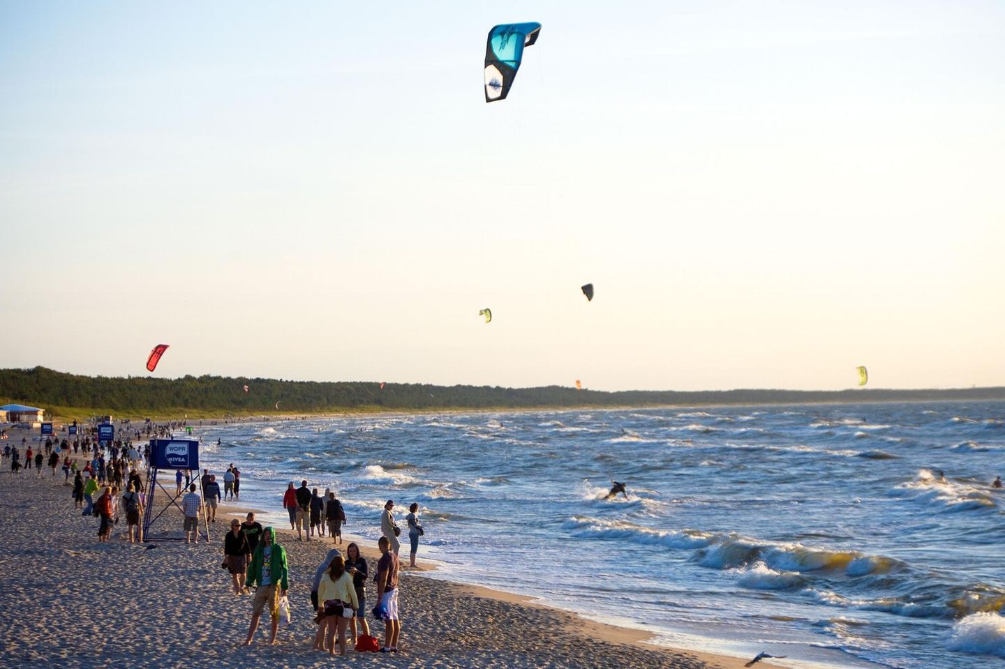 Leute lassen Drachen steigen am Strand