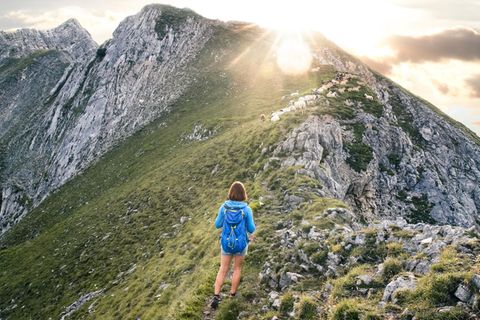 Frau wandert in einer Berglandschaft  Frau wandert in einer Berglandschaft