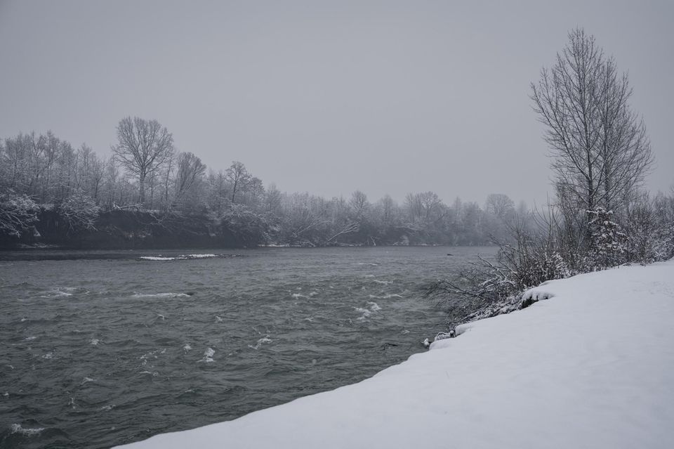 Die ufer des Flusses sind mit Schnee bedeckt