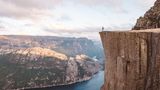 Mensch auf flachem Felsen, Abgrund, unten (600 Meter tiefer) der Fjord