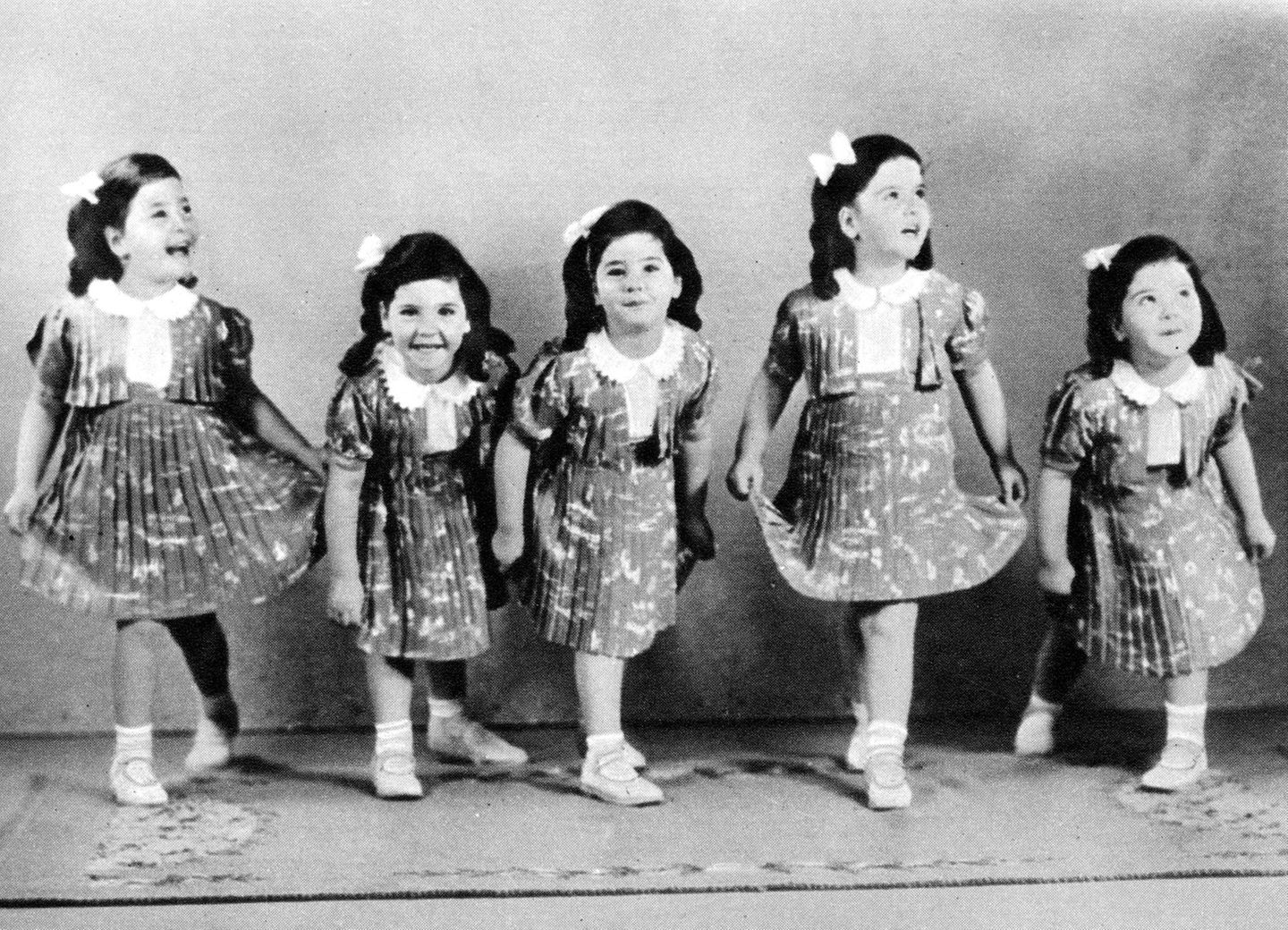 Die berühmten Dionne Fünflinge aufgereiht im Kleidchen 1939