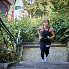 Eine junge Frau rennt Treppenstufen hoch