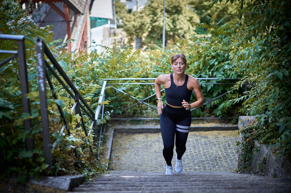 Eine junge Frau rennt Treppenstufen hoch