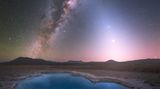 Unten leuchtet ein kleiner See in strahlendem Blau, darüber erstreckt sich die Milchstraße spektakulär am Nachthimmel, begleitet vom sanften Leuchten des Zodiakallichts. Astronom und Astrofotograf Yuri Beletsky fotografierte die Szenerie in der chilenischen Atacama-Wüste.