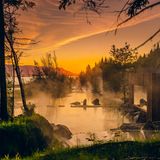 Infinity Pool mit Felsen dazwischen, das Wasser dampft. Abendstimmung.