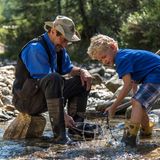 Mann und Junge sitzen am Fluss und waschen Gold.