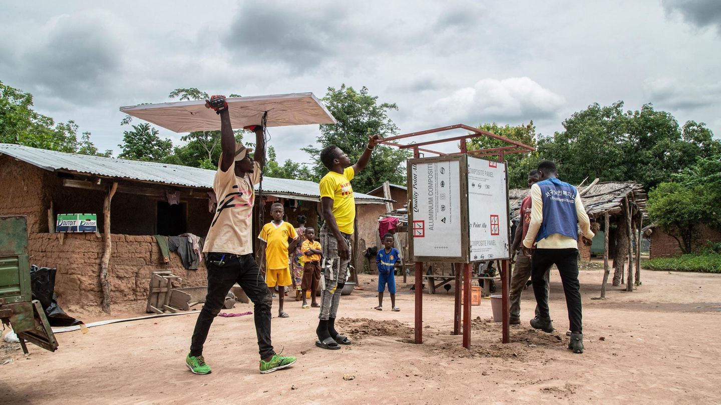 Ein Solarkiosk für die Zukunft Zwei Männer errichten für das Start-up Sunhut einen Solarkiosk in Atonsu, einer Siedlung im Südosten Ghanas. In den Kiosken können die Menschen etwa Handys und Radios aufladen