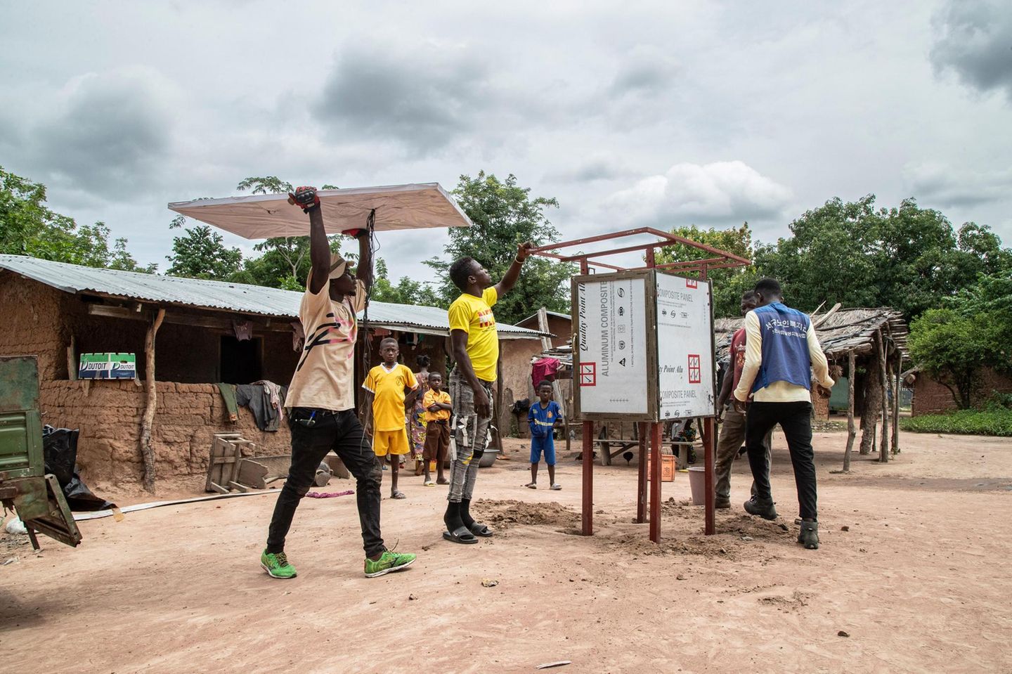 Ein Solarkiosk für die Zukunft Zwei Männer errichten für das Start-up Sunhut einen Solarkiosk in Atonsu, einer Siedlung im Südosten Ghanas. In den Kiosken können die Menschen etwa Handys und Radios aufladen