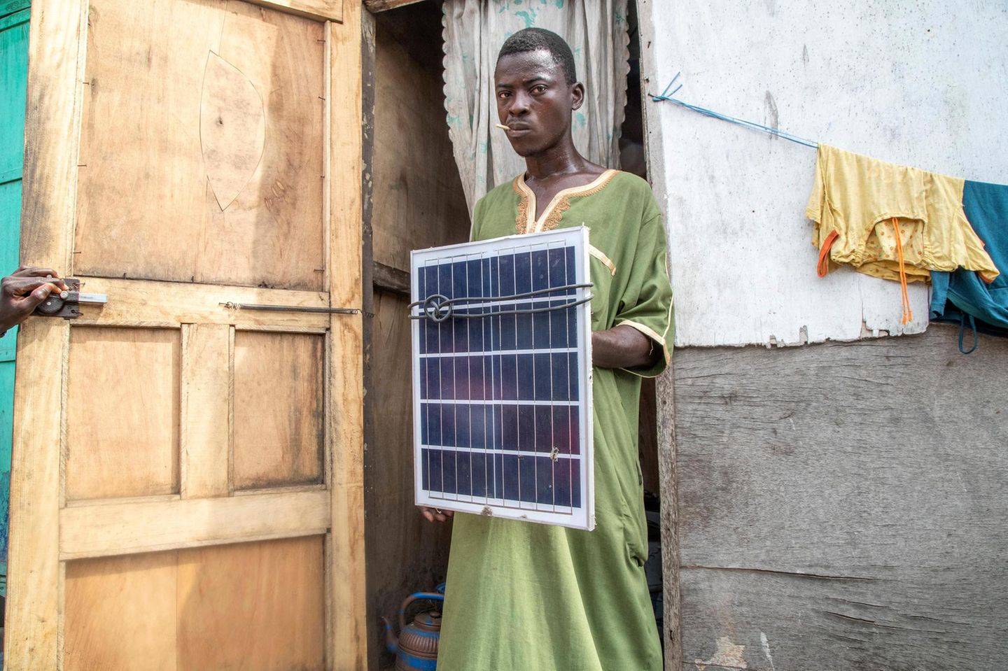 Ein Müllarbeiter mit defektem Solarpaneel: Nur der Metallrahmen lässt sich wiederverwenden, der Rest ist wertlos – und trägt so zu Ghanas Elektromüllproblem bei. Bei den neuen Paneelen von Sunhut dagegen lassen sich einzelne Module ersetzen