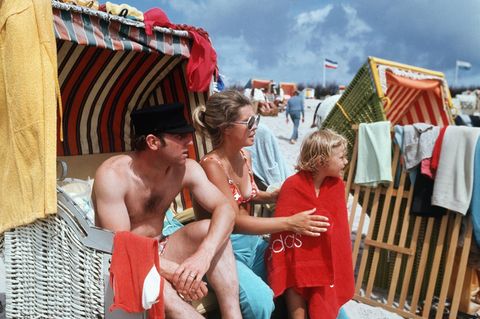 Uwe Seeler sitzt in einem Strandkorb, neben ihm seine Frau, die die Tochter abtrocknet