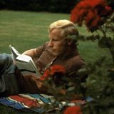 Berti Vogts liegt lesend auf dem Rasen