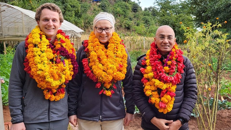 Empfang in Danda Basaha Geschäftsführerin, Projektleiter und Leiter der Partnerorganisation mit vielen bunten Blumenkränzen um den Hals