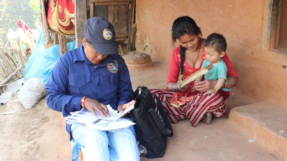 Gesundheitshelferin in Danda Basaha, Nepal Eine Gesundheitshelferin untersucht ein Kleinkind in Danda Basaha