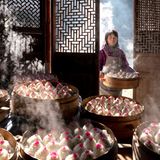 Eine Frau trägt einen Korb mit Reisbällen