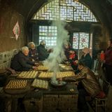 Alte Menschen mir dampfendem Gebäck in einem Raum mit Glastür