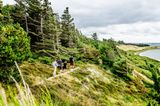 Wanderer auf einem Wanderweg entlang der Küste der Insel Venø