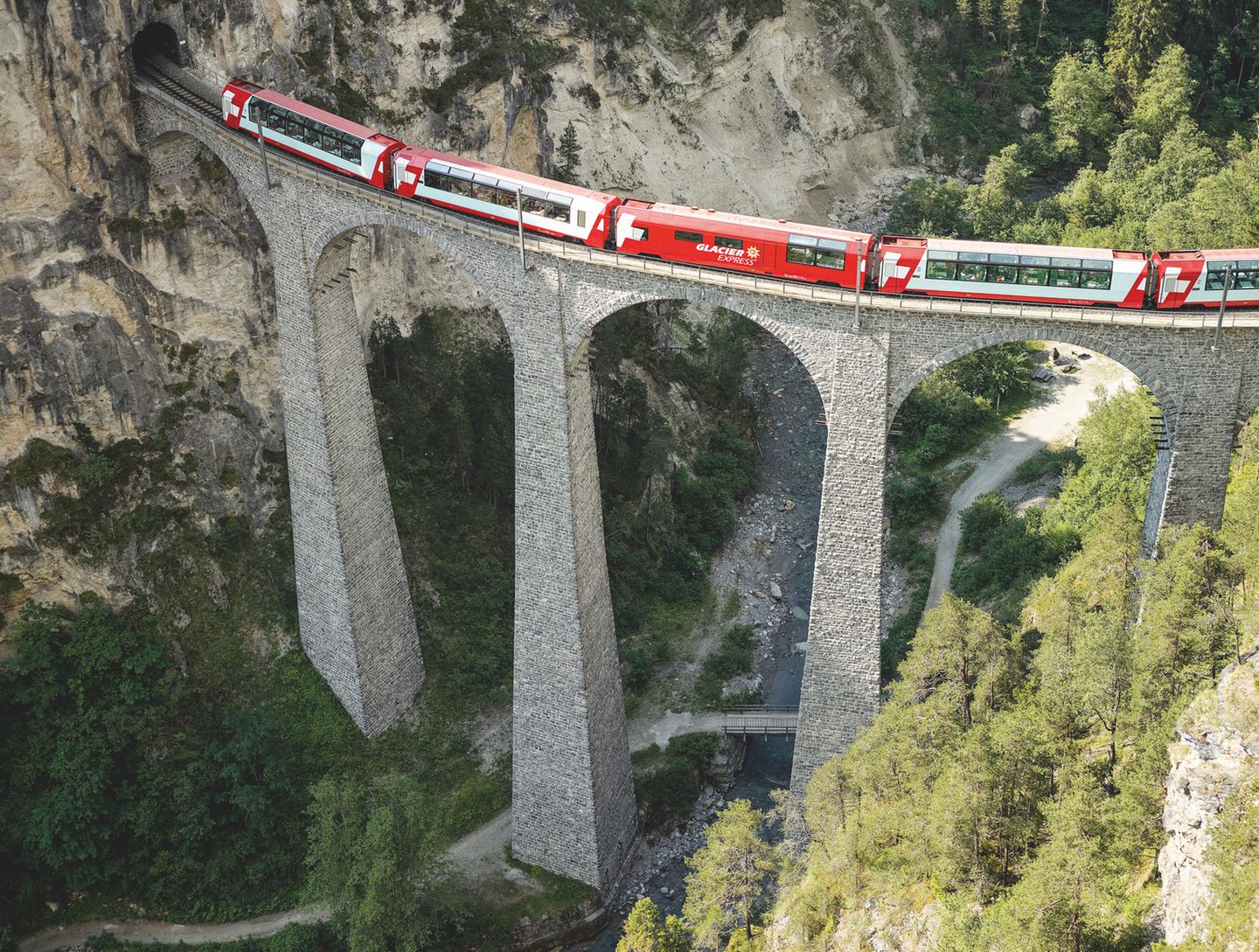 Glacier Express: Entschleunigen mit Bergpanorama Viadukt, Felsen, Schlucht. Über die Brücke fährt ein Zug.