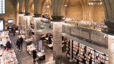Interior of Dominican church converted into a bookstore with restaurant, customers, cathedral ceilings and pillars of the church in Maastricht, Netherland