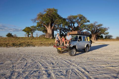 Paar mit zwei Söhnen auf ihrem Jeep  im Nxai Pan National Park in der Kalahari Wüste in Afrika