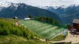 Inmitten der malerischen Schweizer Berglandschaft liegt die Ottmar-Hitzfeld-Arena, benannt nach der Schweizer Trainerlegende, die viele Erfolge mit dem FC Bayern München und Borussia Dortmund feiern konnte. 2009 stiftete Hitzfeld einen neuen Kunstrasen für das Stadion. Das Spielfeld auf einem Bergplateau ist kleiner als üblich, was zu besonderen Regeln führt: Statt elf stehen nur acht Spieler pro Team auf dem Platz, Abseits und Rückpassregel gibt es nicht. 
