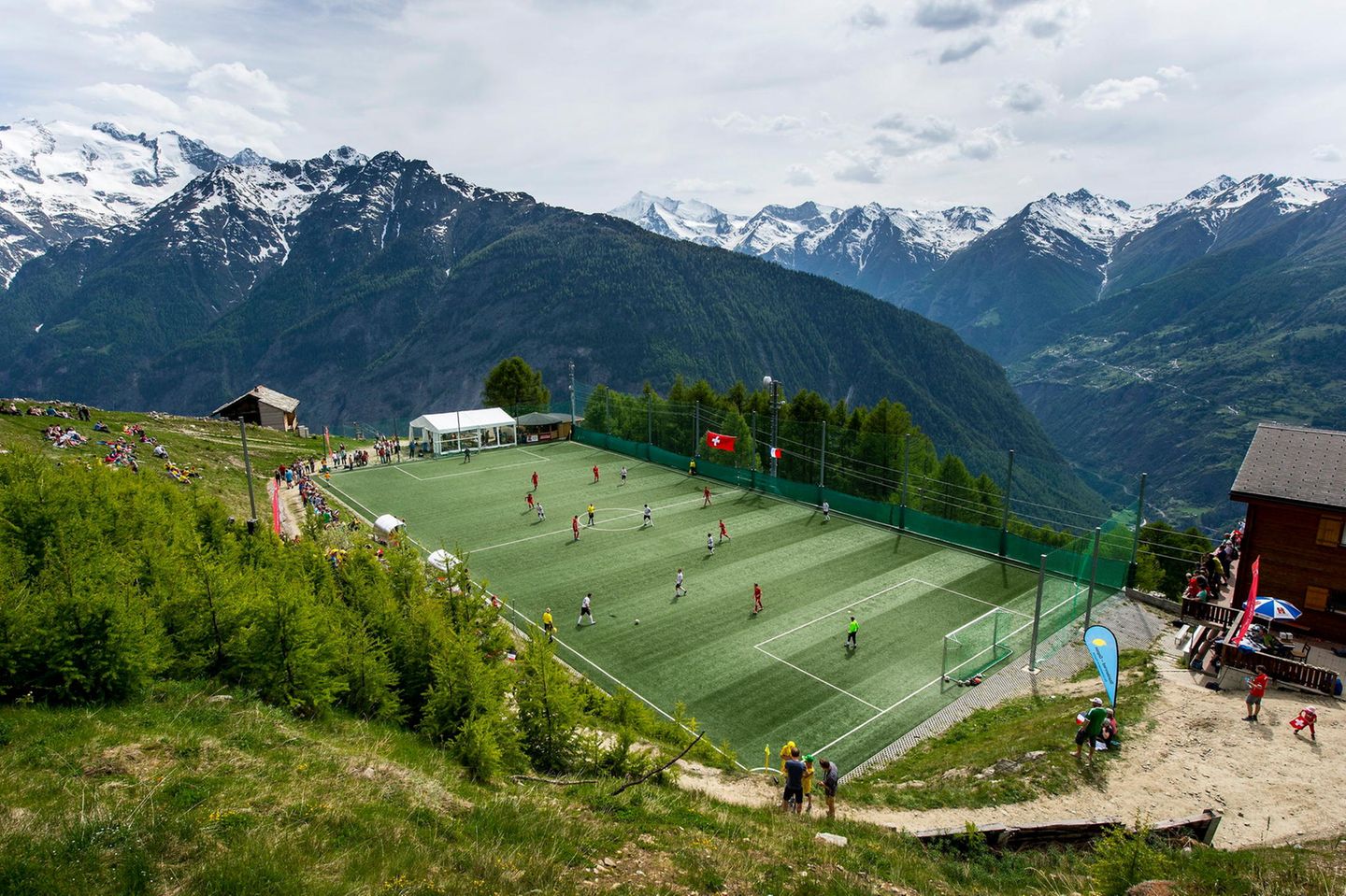 Inmitten der malerischen Schweizer Berglandschaft liegt die Ottmar-Hitzfeld-Arena, benannt nach der Schweizer Trainerlegende, die viele Erfolge mit dem FC Bayern München und Borussia Dortmund feiern konnte. 2009 stiftete Hitzfeld einen neuen Kunstrasen für das Stadion. Das Spielfeld auf einem Bergplateau ist kleiner als üblich, was zu besonderen Regeln führt: Statt elf stehen nur acht Spieler pro Team auf dem Platz, Abseits und Rückpassregel gibt es nicht. 