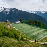 Inmitten der malerischen Schweizer Berglandschaft liegt die Ottmar-Hitzfeld-Arena, benannt nach der Schweizer Trainerlegende, die viele Erfolge mit dem FC Bayern München und Borussia Dortmund feiern konnte. 2009 stiftete Hitzfeld einen neuen Kunstrasen für das Stadion. Das Spielfeld auf einem Bergplateau ist kleiner als üblich, was zu besonderen Regeln führt: Statt elf stehen nur acht Spieler pro Team auf dem Platz, Abseits und Rückpassregel gibt es nicht. 