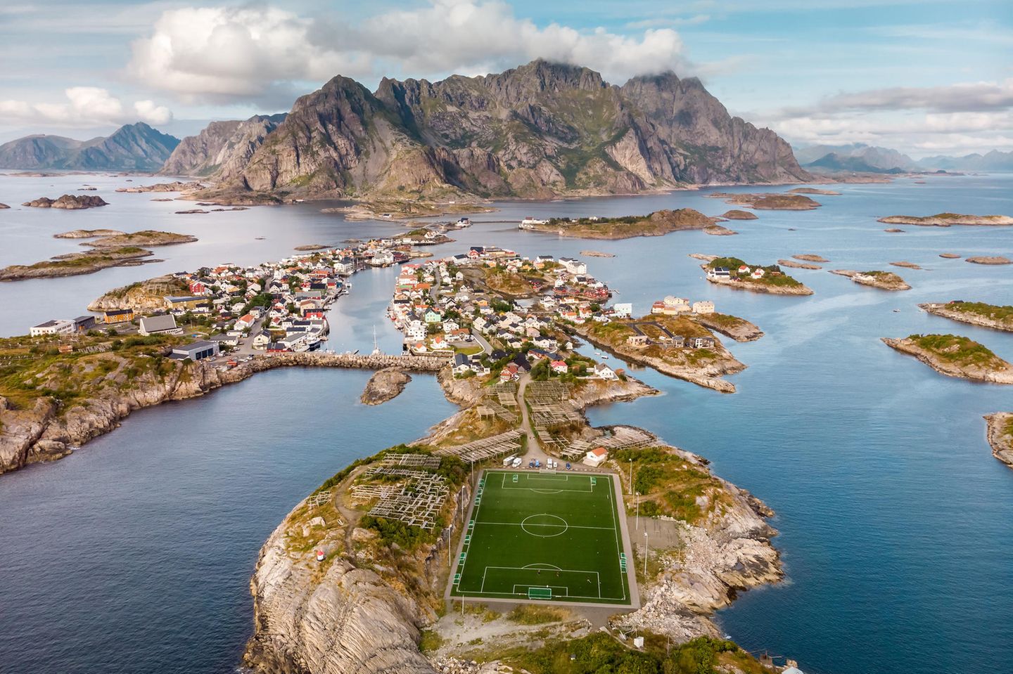 Henningsvaer, Norwegen Hoch im Norden, auf der Inselgruppe der Lofoten liegt umgeben von Wasser im kleinen Fischerdorf Henningsvær ein Fußballplatz. Vor allem auf Luftaufnahmen kommt die beeindruckende Lage des Freilichtstadions zur Geltung. Der heimische Fußballclub Henningsvær IL ist zwar nur ein kleiner Amateurverein, doch aufgrund der spektakulären Kulisse diente sein Platz bereits als Drehort eines Werbespots für das Champions-League-Finale 2018. Spätestens seitdem ist der Platz unter Fußballfans weltweit bekannt.