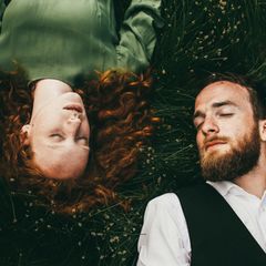 Päarchen liegt mit geschlossenen Augen im Gras