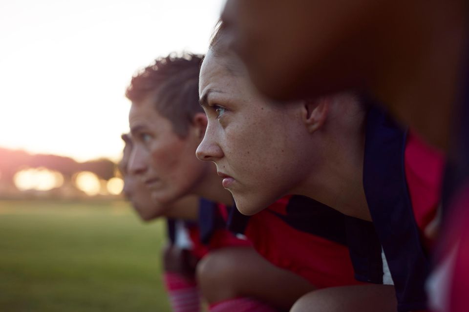 Eine Sportmanschaft steht fokusssiert auf dem Feld