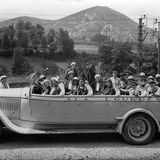 Touristen in einem offenen, altmodischen Reisebus