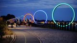 Beleuchtete große Ringe am Ufer der Loire, dahinter die Altstadt, fast nachts