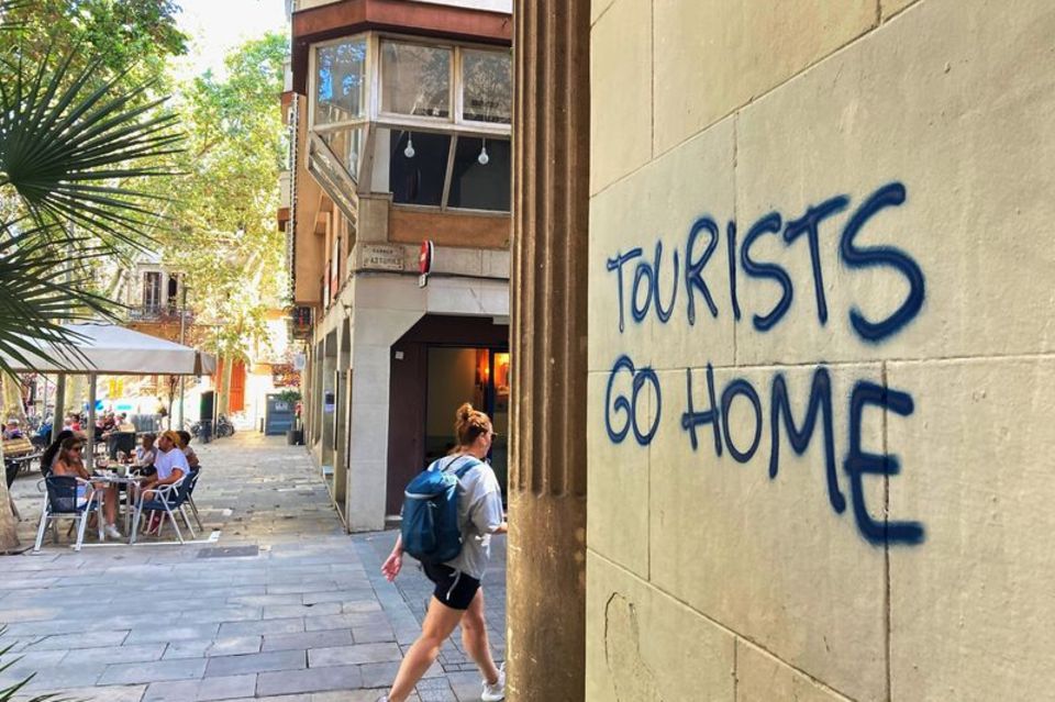 "Tourists Go Home": Botschaft an einer Wand im Künstlerviertel Vila de Gràcia in Barcelona 1.3333