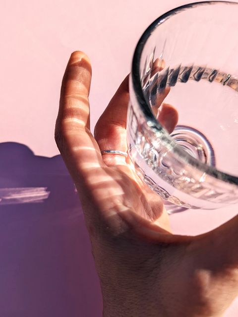 Hand, die ein Wasserglas hält und Joghurtglas