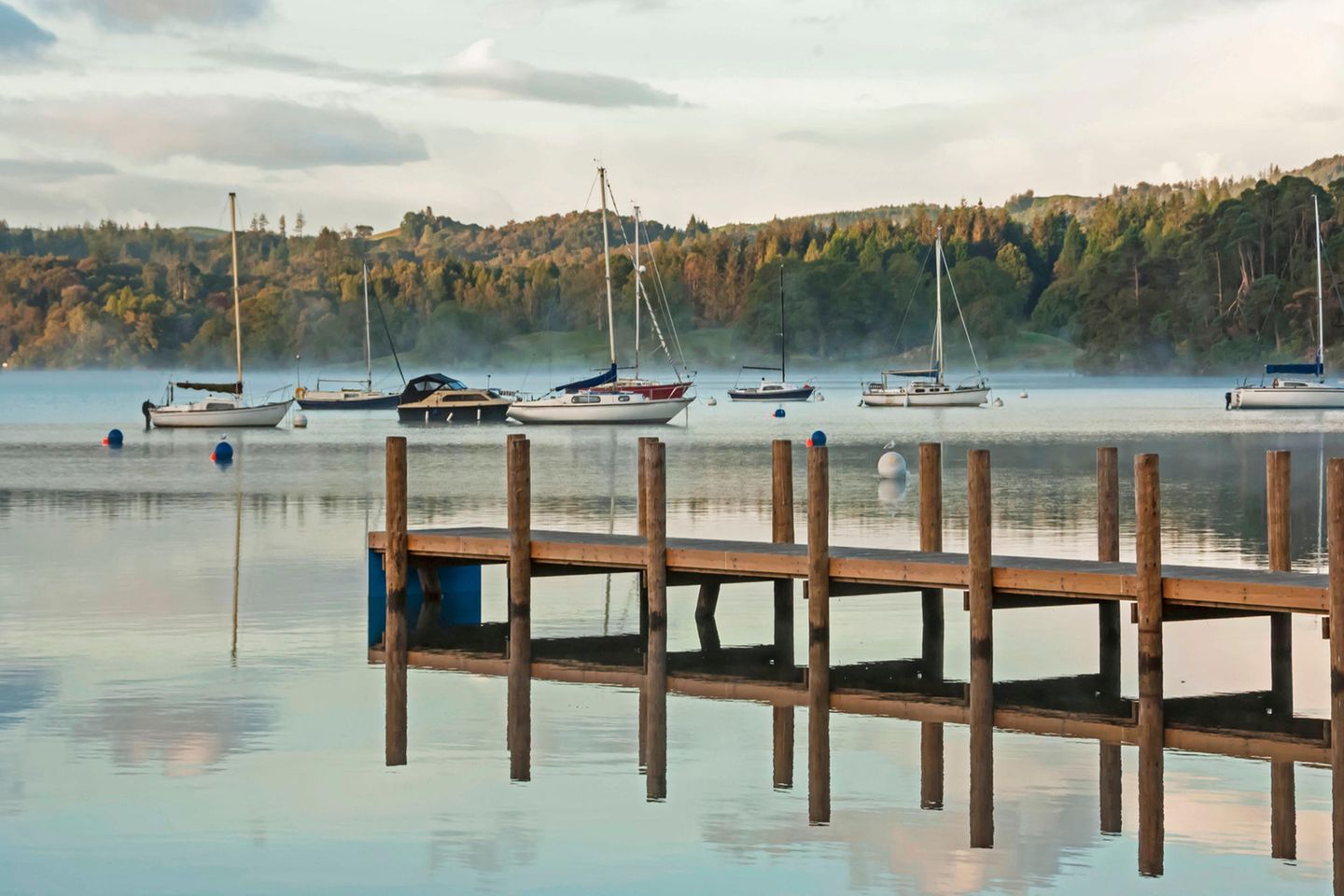 Lake District: Englands Seenlandschaft Ein Steg im Nebel mit Booten im Hintergrund
