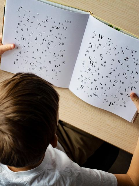 Ein Kind schaut in ein Buch mit Buchstaben