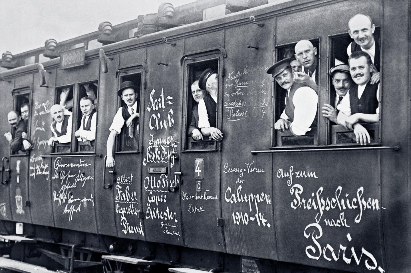 Reservisten 1914 in einem Zug, auf dem in weißer Farbe unter anderem geschrieben steht: "Auf zum Preißschießen nach Paris"